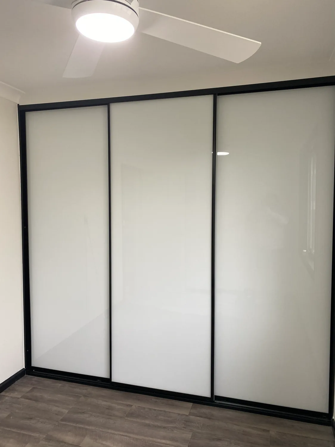 Super white glass sliding door wardrobe with black frames
