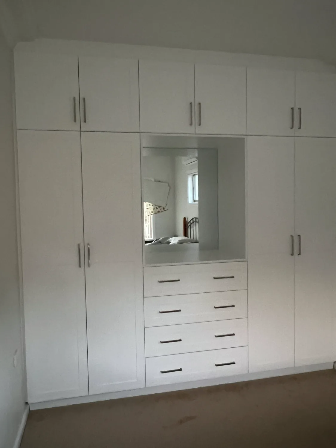 Custom cabinetry wall with mirror and drawers
