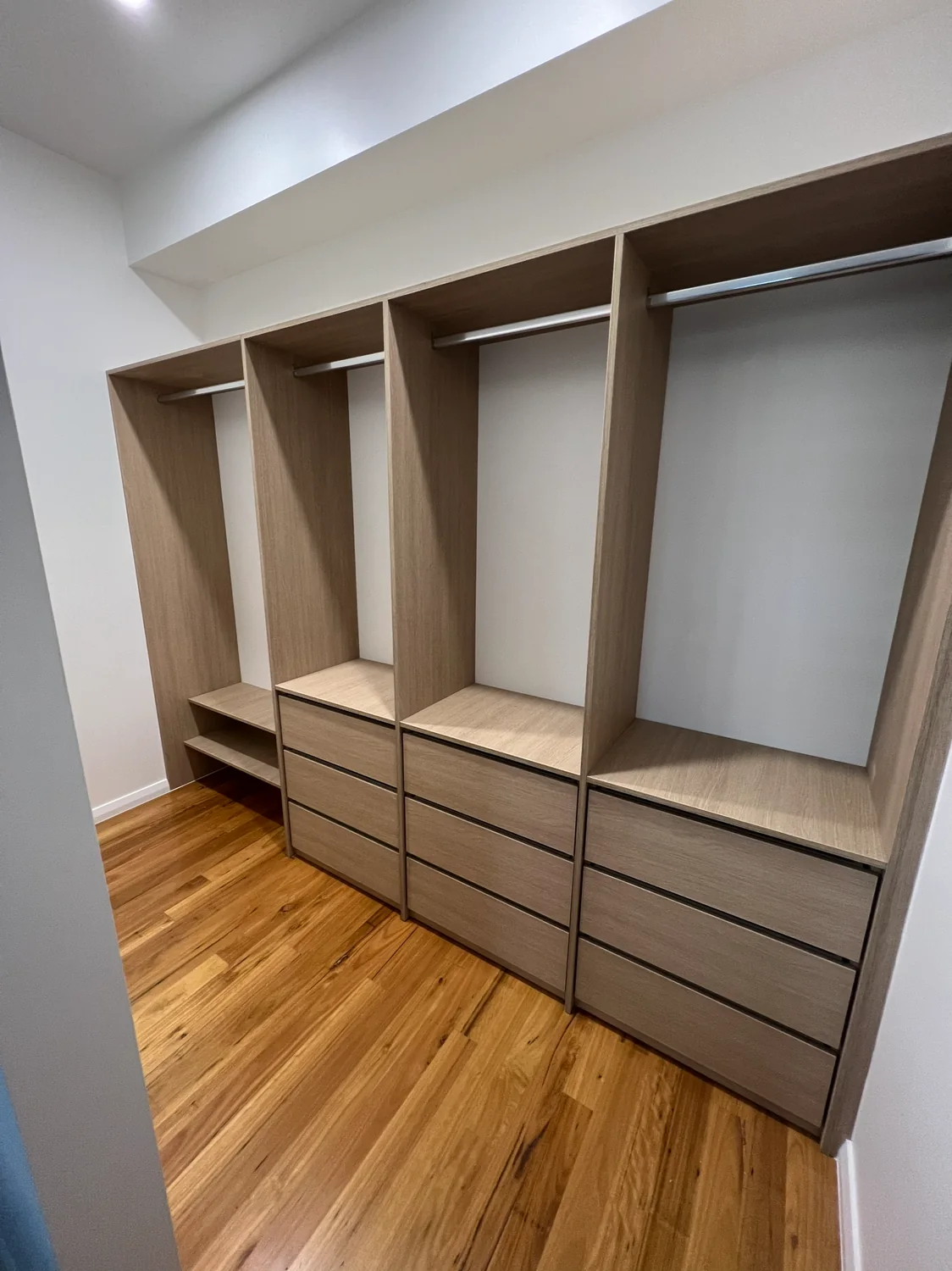 Walk-in robe with woodgrain shelving and drawers